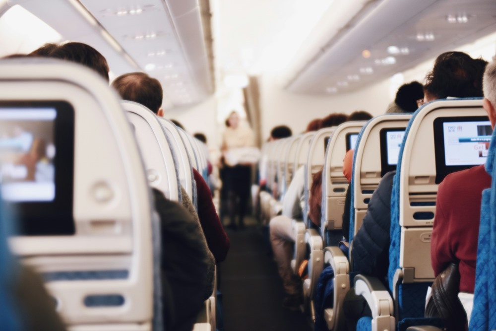 This photo depicts an airplane aisle during flight.