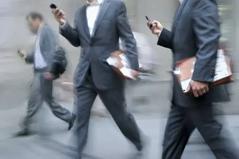 businessmen using mobile phones while walking