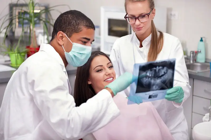 Dentist team and patient looking at x-ray image