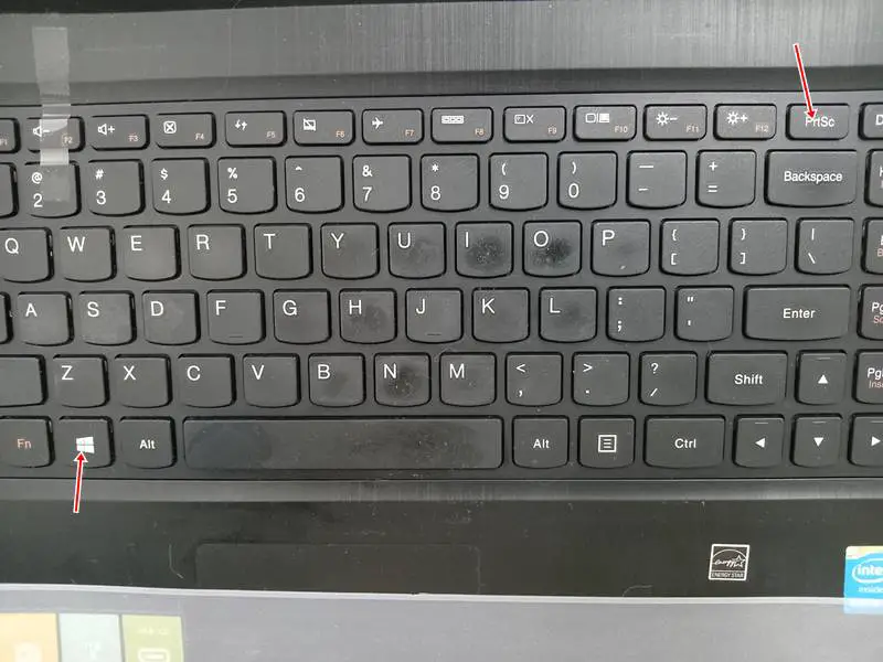 laptop keyboard with red arrows pointing the Windows and PrtSc keys