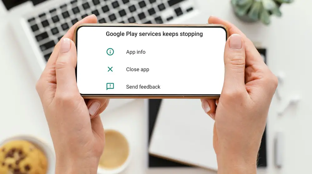 How to Fix "Google Play Services Keeps Stopping" Error: This photo shows a woman's hands holding a smartphone with the screen displaying the "Google Play services keeps stopping" error.