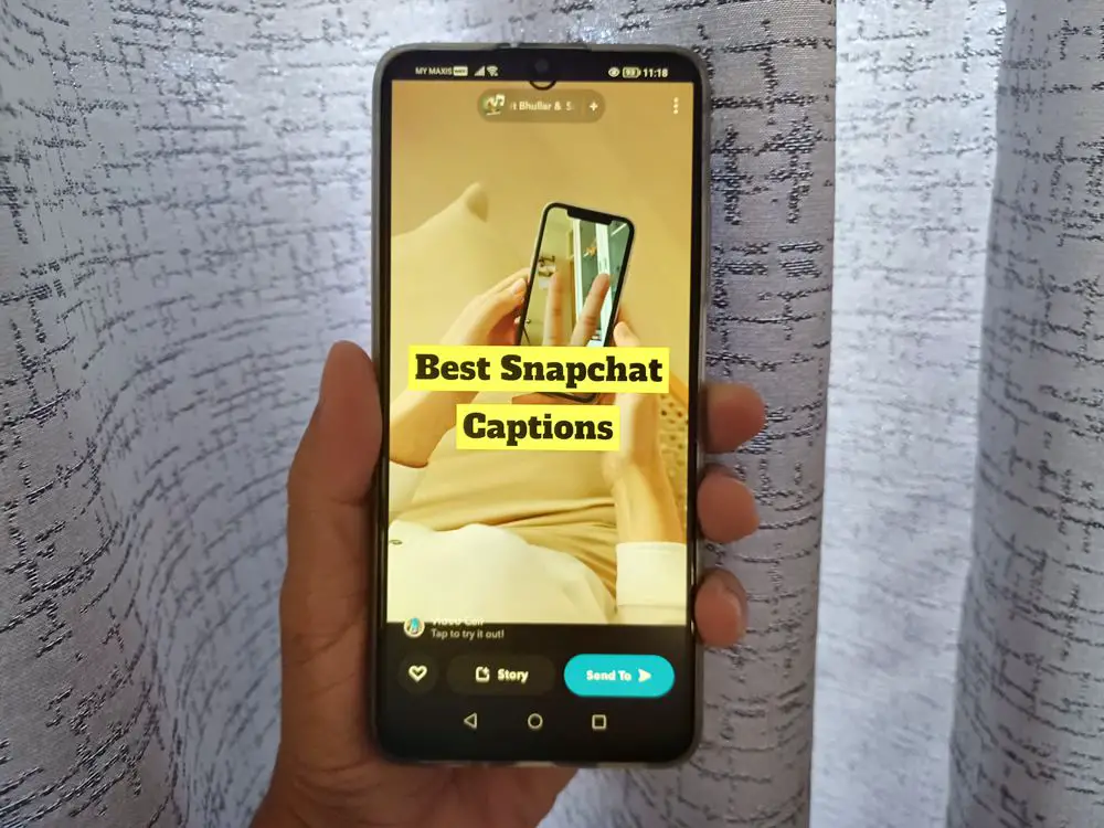 This photo captures a man's hand holding a smartphone, displaying a Snapchat snap with the caption 'Best Snapchat Captions' on its screen.