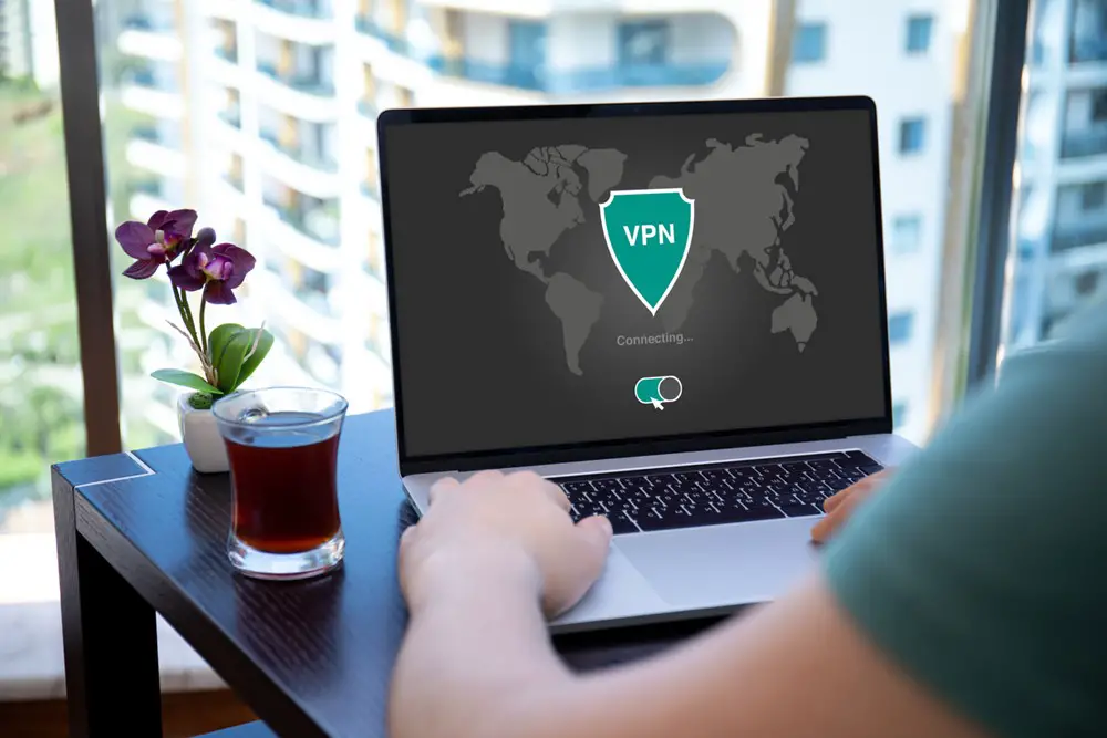 How to Set Up VPN on Home Network: This photo depicts a man using a VPN application to create secure Internet protocols for a private network on his laptop screen.