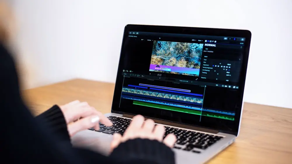 How to Edit 4K Videos Without Losing Quality: This photo depicts a person editing video with a laptop.