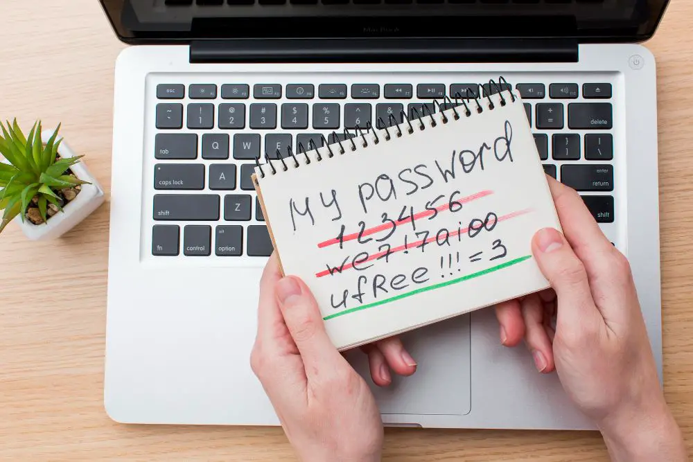 This photo depicts a person's hands holding a notebook with several examples of passwords.