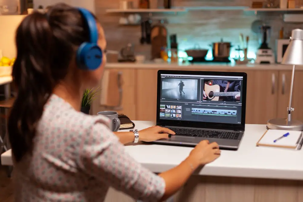 This photo depicts a woman editing video footage with her laptop.