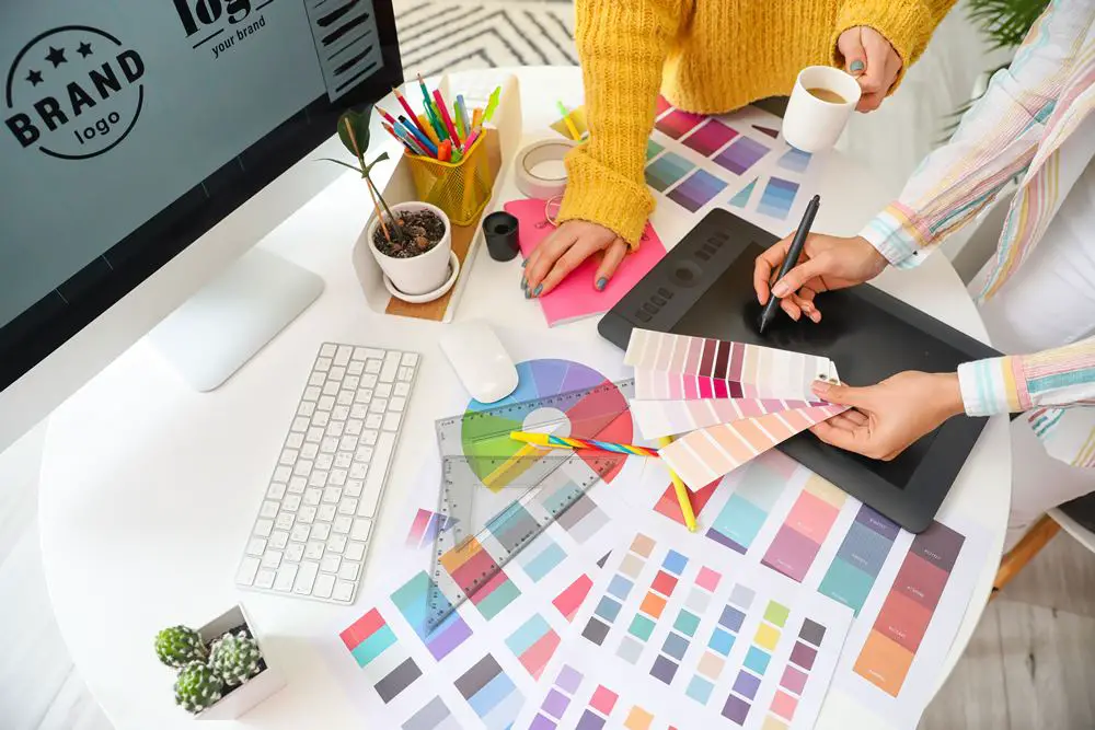 Top 5 Benefits of Outsourcing Graphic Design Projects: This photo depicts two female graphic designers working in the office.