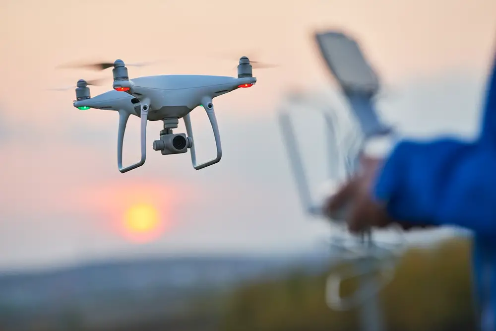 This photo depicts an individual flying a drone at sunset.