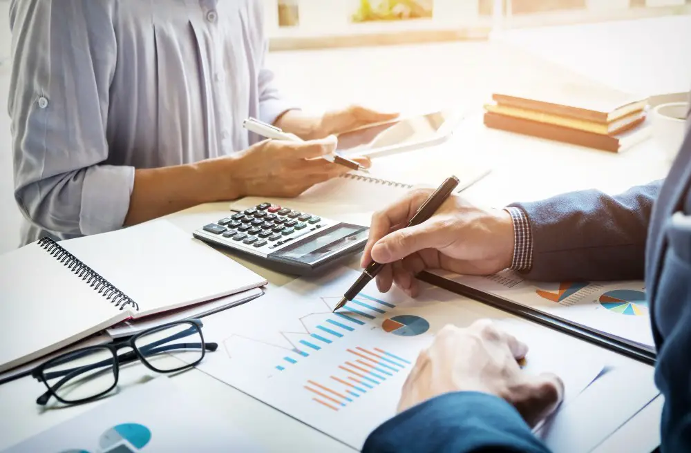 Strategic Category Management in Procurement: This photo depicts two business professionals preparing reports, calculating, or checking balances.