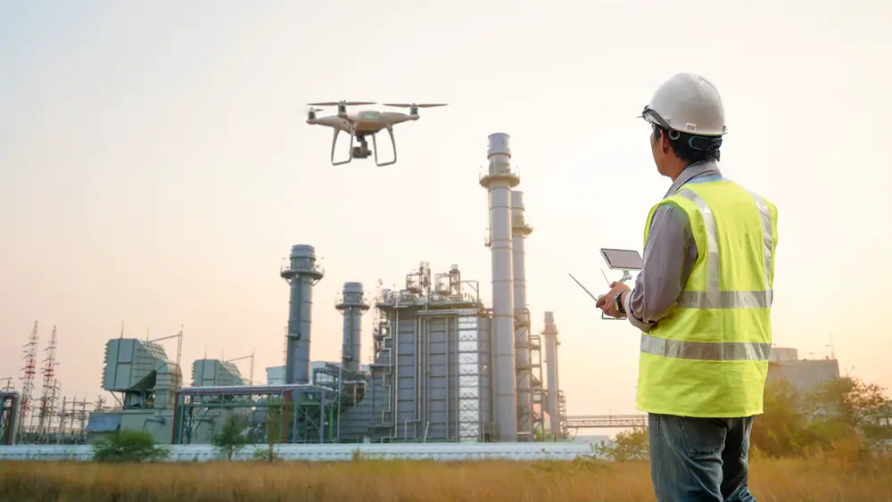 This photo depicts an operator inspecting the surrounding area of a power plant using a drone.