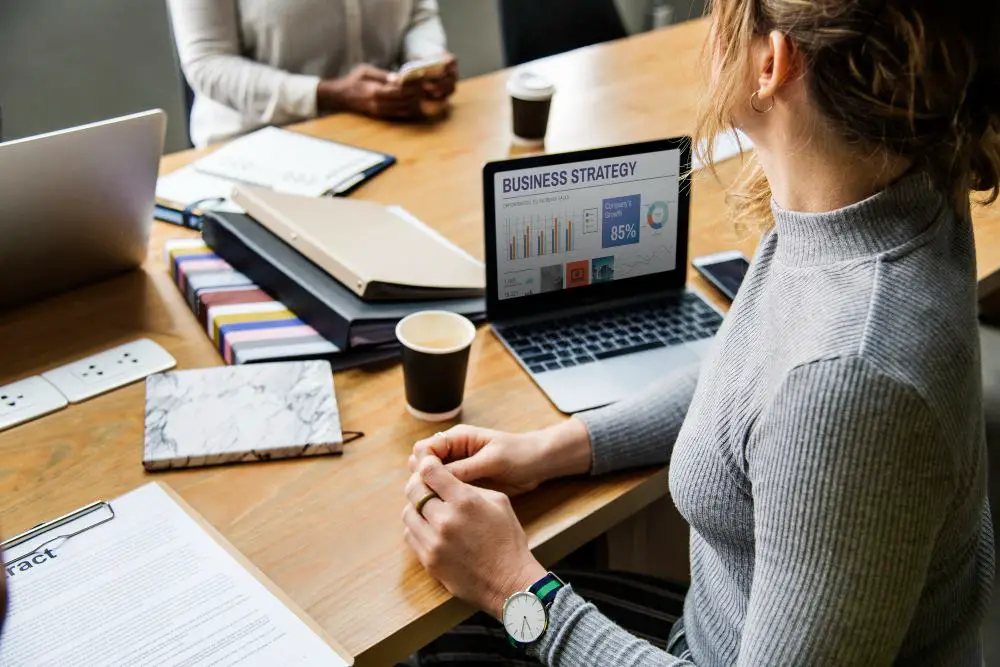 This photo shows a group of business people overseeing proposal management software.