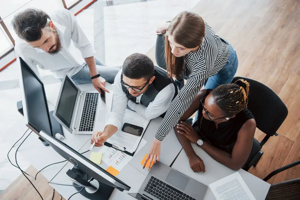 This photo shows a group of people busy working with their computers in the office.