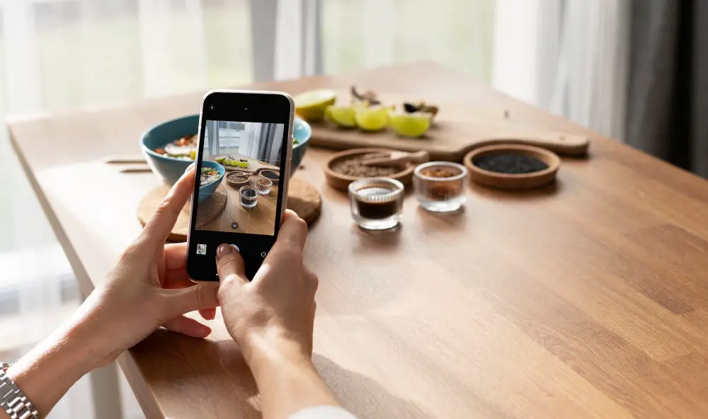 This photo depicts a woman taking photos using her smartphone.